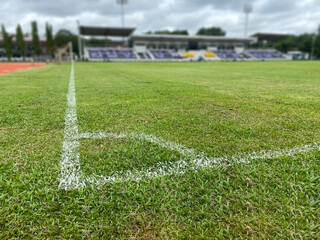 white line at the corner of soccer field blured background no people. sport concept. © capplebkk