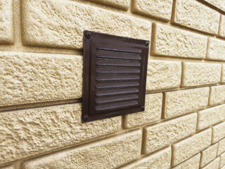 Ventilation hood on a brick wall of a house