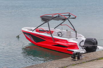 Moored red-white-black motorboat on the background of the sea