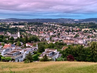 Stadt Adliswil - im Sihltal. Abendlicht / Polarlicht mit rosa und violett gefärbten Himmel  Blick auf die Wohngemeinde und die Dächer - Wohnhäuser - Querformat