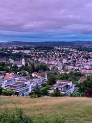 Stadt Adliswil - im Sihltal. Abendlicht mit rosa und violett gefärbten Himmel  Blick auf die Wohngemeinde und die Dächer - Wohnhäuser / Hochformat