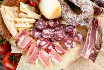 Prodotti tipici della gastronomia sarda: pecorino, salsiccia secca di maiale, guanciale e pane...