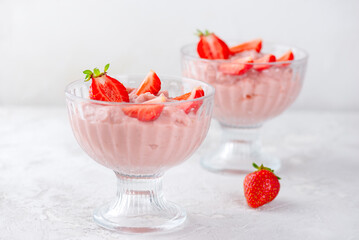 Vegan whipped tofu and strawberry mousse dessert in a glasses on a white table. Lactose and sugar free.