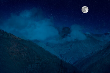 Mountain Road through the forest on a full moon night. Scenic night landscape of country road at night with large moon