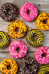 Set of colorful donuts on wooden background