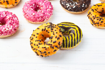 Set of colorful donuts on wooden background