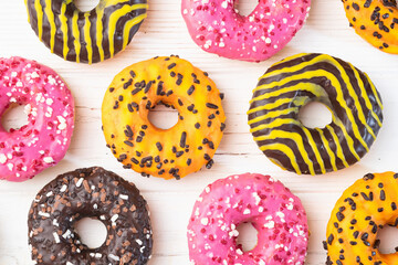 Set of colorful donuts on wooden background