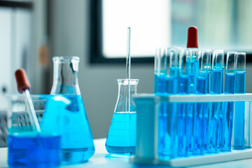 A collection of blue liquid in glass beakers and test tubes