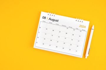 August 2024, Monthly desk calendar for 2024 year and pen on yellow background.