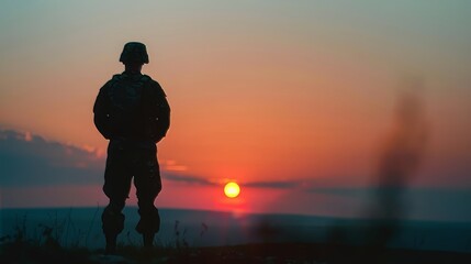 Fototapeta premium Silhouette of soldier standing against sunset backdrop. Veterans Day, Memorial Day, Independence Day, USA celebration. Patriotism, protection, honor.