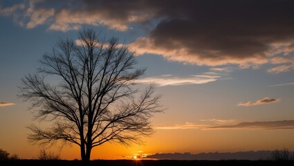 Fiery orange sun dips below the horizon, casting a red glow on clouds across the vast landscape