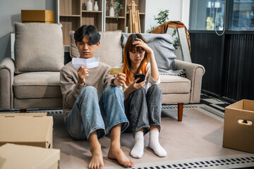  A stressed young couple faces financial challenges, struggling with debt and bills. Despite the...