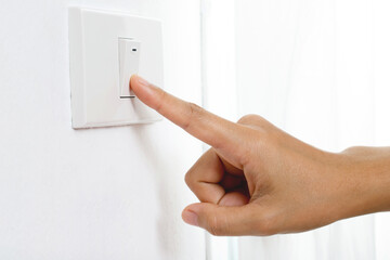 Turn off the light, close up female hand is closing the power switch. Save energy, reduce global...