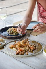 Young woman having dinner in the Mediterranean restaurant. Various dishes served on the table.