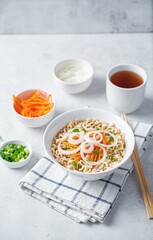 Ramen noodles with carrots and onion slices in a bowl