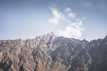 Obraz premium Rocky Tien Shan mountain range in Tajikistan in Pamir in cloudy weather in evening, colorful mountains and clouds for background