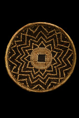 Traditional South African woven basket with geometric paterns on a black background.