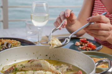 Young woman having dinner in the Mediterranean restaurant. Various dishes served on the table.