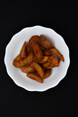 Rustic potatoes in a plate. Delicious fried potatoes.