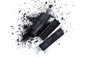 Charcoal sticks with scattered charcoal powder, isolated on a white background, showcasing the raw materials used in art and drawing, ideal for themes related to creativity and artistic tools.