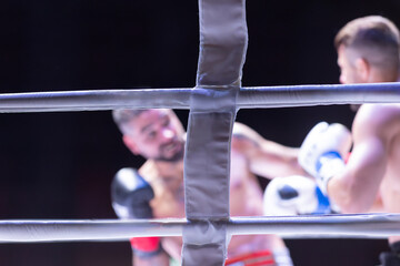 Fototapeta premium A man is boxing and the referee is watching