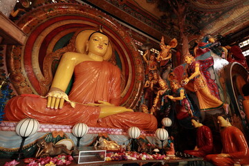 Big colorful Buddha statue in Gangaramaya Temple. Sacred Buddhist Temple in Sri Lanka