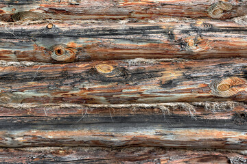 The wooden log wall of the old barn in the village, with its natural background and wood texture.