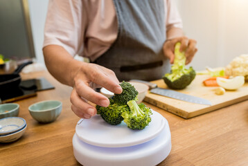 Chef at the kitchen preparing lentils soup with cauliflower and broccoli
