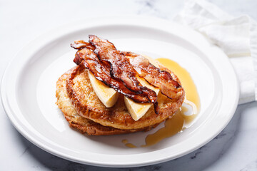 French toast with bacon, banana and maple syrup.