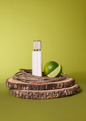 A white perfume bottle stands on oak planks next to a slice of lime