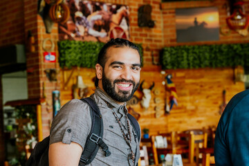 Obraz premium Latin man with bag enjoying his vacation in Colombia. Culture, travel and holidays. Restaurant.