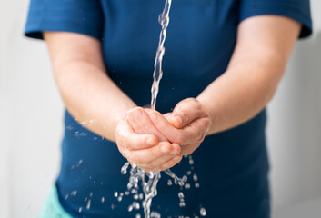 Closeup of woman washing hands in a city fountain