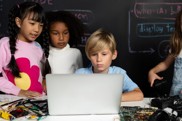 In classroom student in STEM class learning about coding robotics car. Smart children watching at...