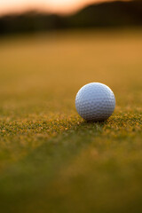Golf ball and clubs in golf field