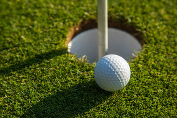 Closeup Golf ball on green grass on course