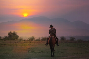 The silhouette of the cowboy and the setting sunset