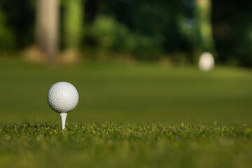 Golf ball and clubs in golf field