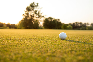 Golf ball and clubs in golf field 