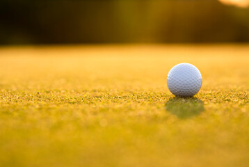 Golf ball and clubs in golf field