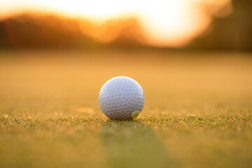 Golf ball and clubs in golf field