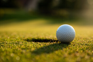 Golf ball and clubs in golf field
