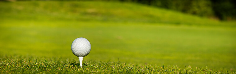Golf ball and clubs in golf field