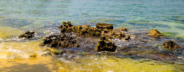 View of an Indian Ocean lagoon with sandy and a coral reef. Wide photo.