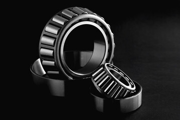 roller bearings on a black background, blank for creativity. Parts for machines and mechanisms in rotation units. selective focus copy space