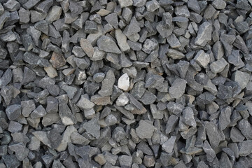 Grey rubble, crushed stone, background, hard texture backdrop. Copy space. Top view. Rocks with sharp edges, broken, close-up. Rough surface for design.