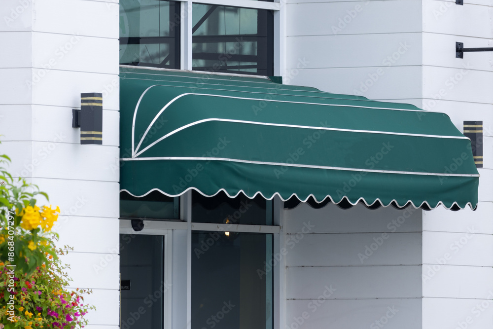 Wall mural a green awning with white trim is covering the entrance to a building