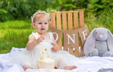 little beautiful girl celebrates her first birthday. boho style. holiday. cake. nature