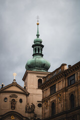 Fototapeta premium Barocke Kirchturmspitze in der Altstadt von Prag unter bewölktem Himmel