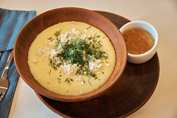 Delicious banoche with cheese and greens in a bowl. Serving in a restaurant. Traditional Ukrainian...