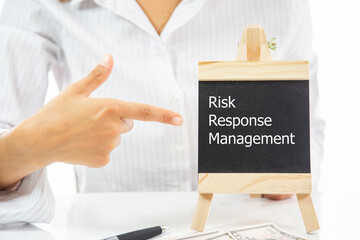 A woman pointing at a blackboard with the word Risk Response Management written on it